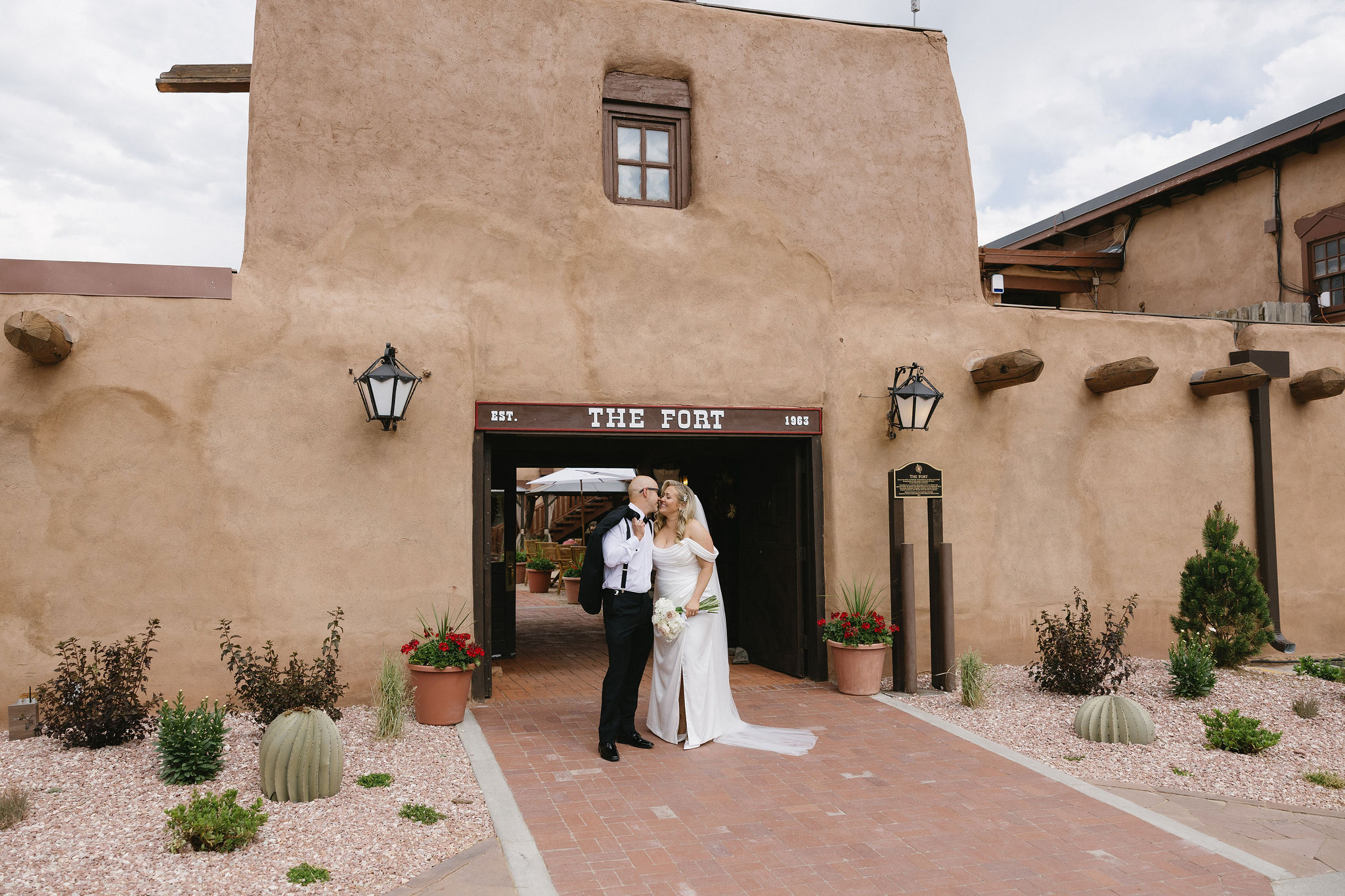 Bride and groom pose for a photo in front of the Fort Restaurant in Morrison before their wedding. 