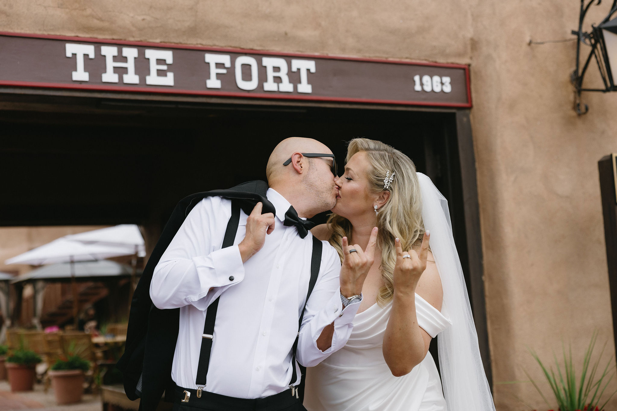 Bride and groom pose for a photo in front of the Fort Restaurant in Morrison before their wedding. 