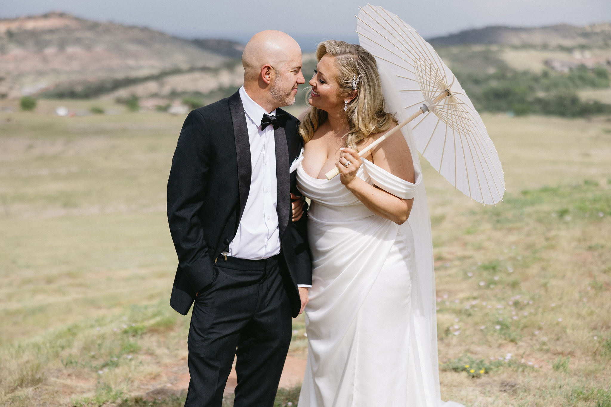 Bride and groom pose with a parasol outside of the Fort Restaurant on their wedding day